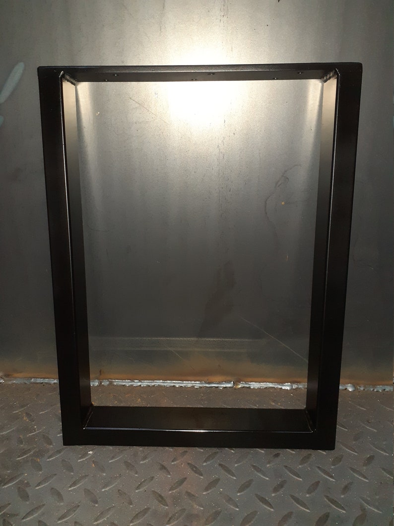 May include: Black metal table legs with a rectangular frame. The legs are welded together at the corners and have a smooth, matte finish.