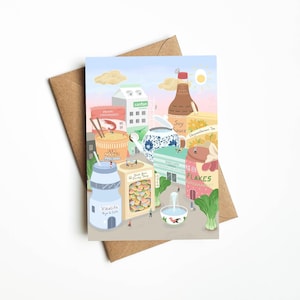 May include: An illustration of a city made of food products. The city includes a cup of noodles, a box of firecrackers, a box of candy, a bottle of soy sauce, a box of tea, a box of cereal, a bottle of milk, a teapot, and a fountain. The city is surrounded by a light blue sky with a yellow sun.