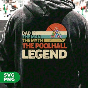 May include: A black hoodie featuring a vintage-style graphic that reads "Dad The Man The Myth The Poolhall Legend". The graphic depicts a pool table with balls and cues in a retro colour scheme.