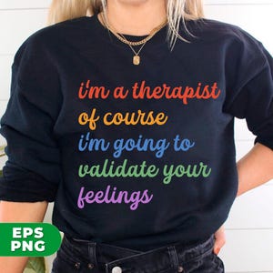 May include: A black sweatshirt with the text "I'm a therapist of course I'm going to validate your feelings" in rainbow colors.