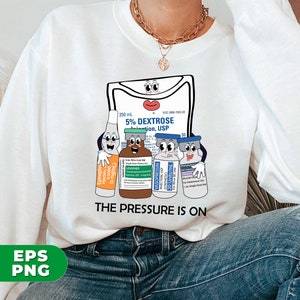 May include: White sweatshirt with a graphic of a cartoon IV bag and vials with the text "The Pressure Is On".