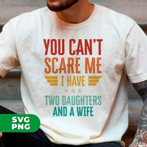 Op de afbeelding: Een wit T-shirt met een vintage-stijl grafische afbeelding met de tekst "You can't scare me I have two daughters and a wife".
