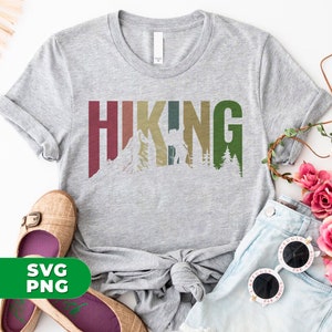 May include: Gray t-shirt with the word "HIKING" in colorful letters with a mountain and a bear silhouette inside the letters.