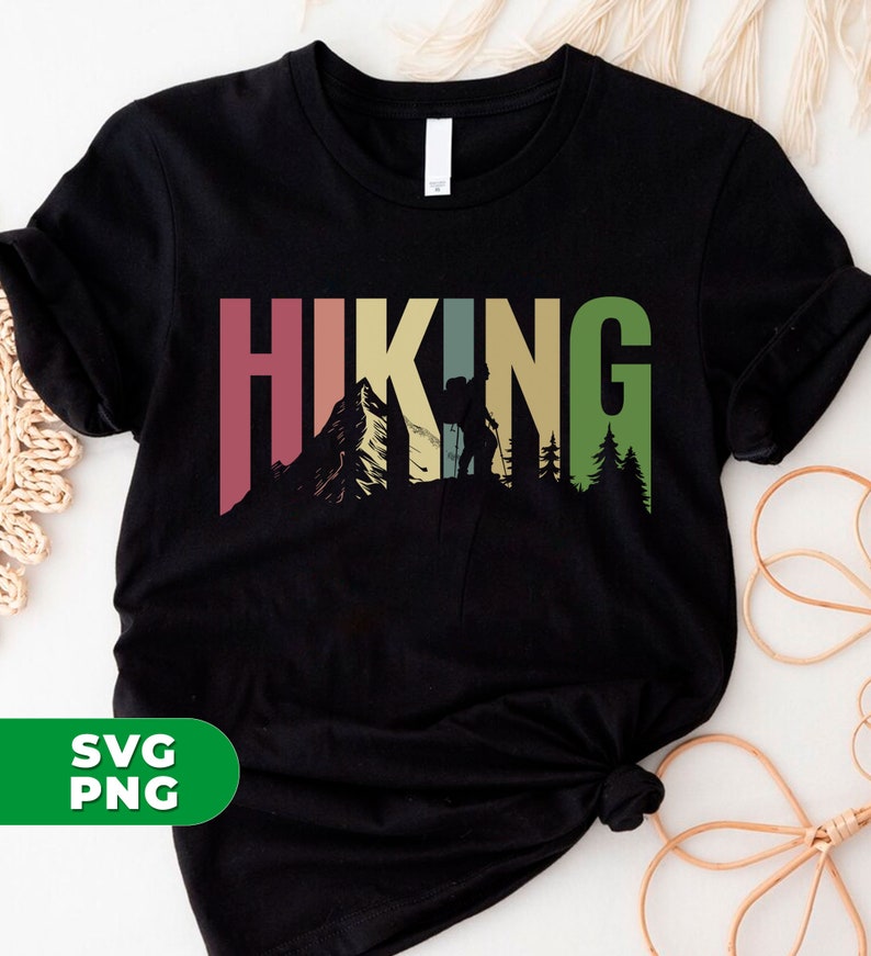 May include: Black t-shirt with a retro-style graphic of the word "HIKING" in colorful letters. A silhouette of a hiker with a backpack is in the middle of the word, with mountains and trees behind it.