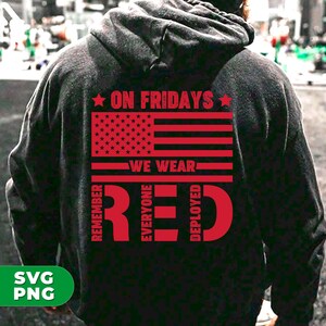 May include: A black hoodie with a red American flag and the text "On Fridays We Wear Red" with the words "Remember Everyone Deployed" surrounding the word "Red".
