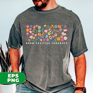 May include: A gray t-shirt with a colorful floral design and the text "GROW POSITIVE THOUGHTS" printed on the front.