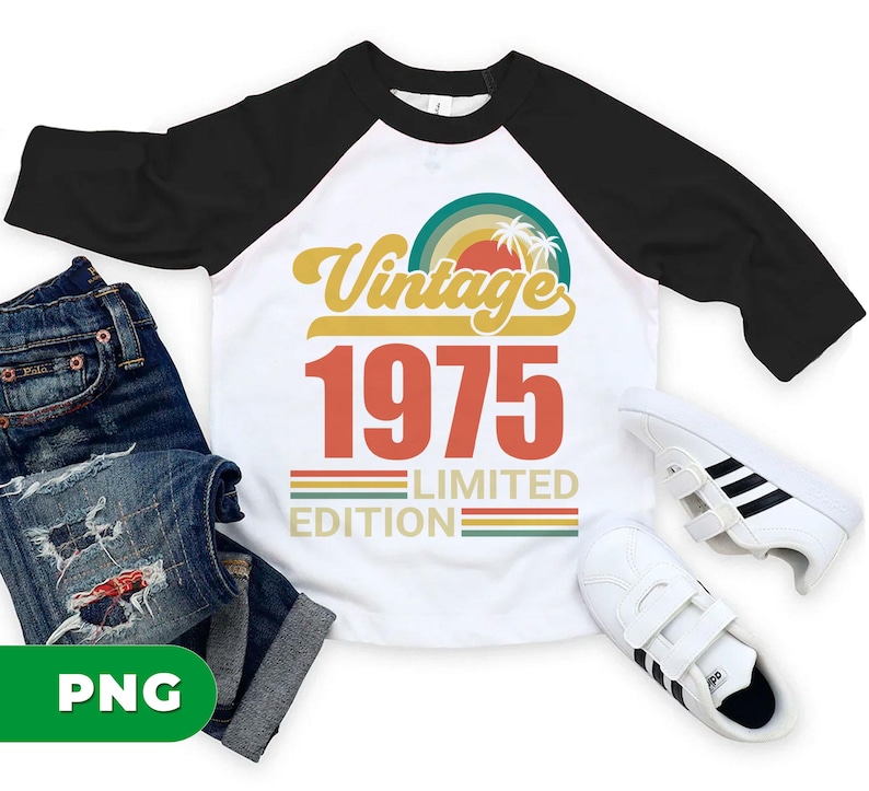 May include: White and black raglan style t-shirt with the text "Vintage 1975 Limited Edition" in orange and yellow. The shirt is paired with blue jeans and white sneakers with black stripes.