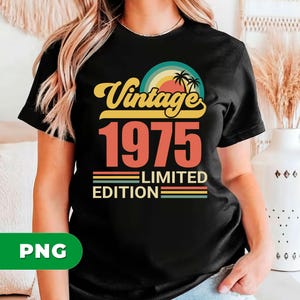 May include: Black t-shirt with a retro design. The design features the word "Vintage" in yellow script above the number "1975" in orange. Below, it reads "Limited Edition" with colorful stripes. A sunset and palm trees complete the design.