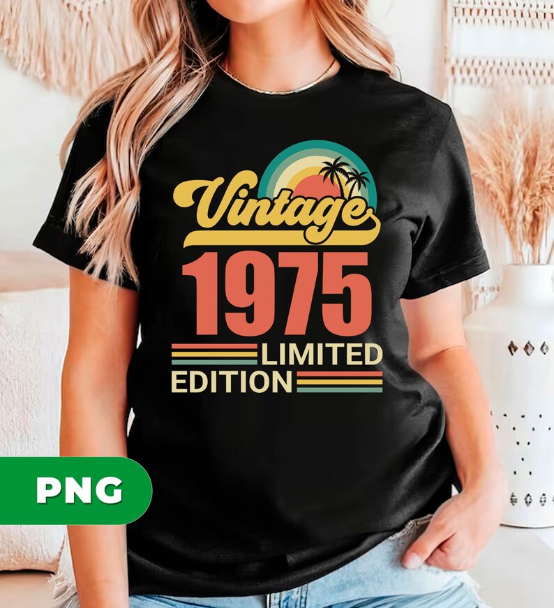 May include: Black t-shirt with a retro design. The design features the word "Vintage" in yellow script above the number "1975" in orange. Below, it reads "Limited Edition" with colorful stripes. A sunset and palm trees complete the design.