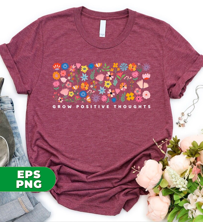 May include: A maroon t-shirt with a floral design and the text "Grow Positive Thoughts" printed on the front.