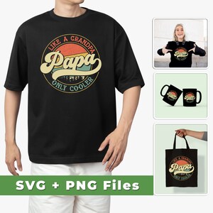 Puede incluir: Una camiseta negra con un gr&aacute;fico de estilo vintage que dice "Como un abuelo, Papa, solo m&aacute;s genial". El gr&aacute;fico presenta una puesta de sol con una silueta de monta&ntilde;a verde. La camiseta se muestra en un modelo que lleva pantalones cortos blancos.