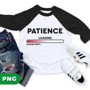 May include: White and black raglan style t-shirt with the words "PATIENCE LOADING PLEASE WAIT..." printed on the front. The image also includes a pair of blue jeans and white sneakers with black stripes.