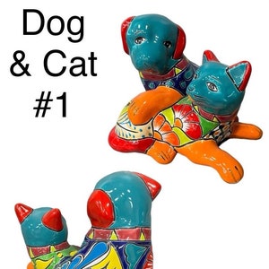 May include: A colorful ceramic dog and cat figurine set. The dog is blue, orange, and red, and the cat is blue, orange, and yellow. The figurines are decorated with intricate floral patterns.