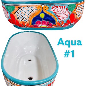 May include: A white ceramic planter with a turquoise rim and colorful floral designs. The planter has drainage holes in the bottom. The text "Aqua #1" is visible in the image.