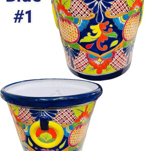 May include: Two blue and white ceramic flower pots with colorful floral designs. The pots have a white interior and a blue rim. The designs feature yellow, red, orange, green, and pink flowers and geometric patterns.