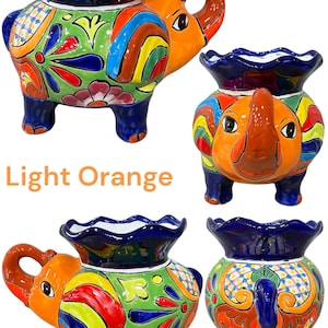 May include: A set of four colorful ceramic elephant planters with a light orange glaze. Each planter features a unique floral design and a scalloped rim.