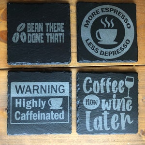 Può includere: Quattro sottobicchieri in ardesia nera con testo bianco. I sottobicchieri presentano detti sul tema del caffè: "Bean There Done That!" "More Espresso Less Depresso" "Warning Highly Caffeinated" e "Coffee Now Wine Later".