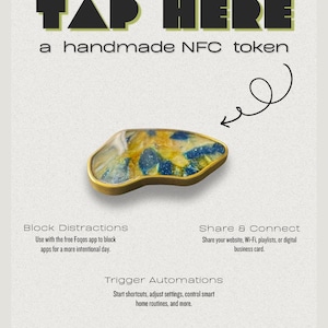 May include: A handmade NFC token with an irregular shape, featuring a gold-colored metal edge and a marbled surface with blue and yellow resin accents. The text reads: TAP HERE, a handmade NFC token, Block Distractions, Share & Connect, Trigger Automations.