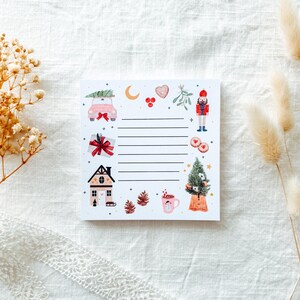 Può includere: Un blocco note bianco con illustrazioni natalizie. Il blocco note presenta un'auto rosa con un albero di Natale, un regalo, una casa, uno schiaccianoci e un albero di Natale. Il blocco note ha delle righe per scrivere.