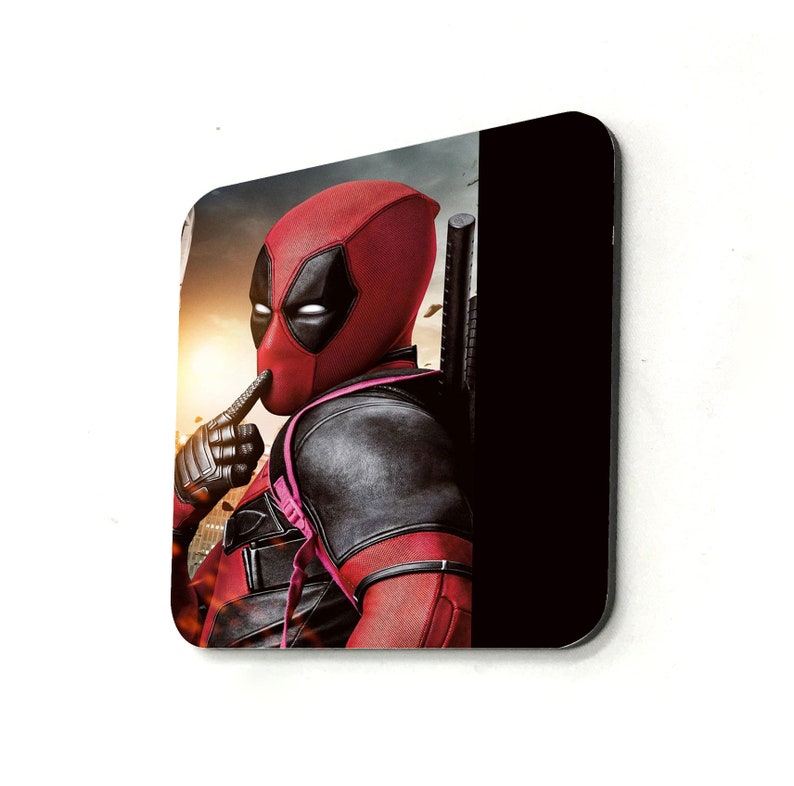 May include: A red and black superhero character with a mask and a red and black suit. The character is holding a finger to their lips, as if to tell someone to be quiet. The character is standing in front of a black background.