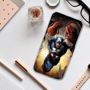 Puede incluir: Una funda de teléfono con una ilustración de cómic de Capitán América en una pose dinámica, volando por el aire con su escudo en la mano. El fondo es una puesta de sol vibrante de color amarillo y naranja.