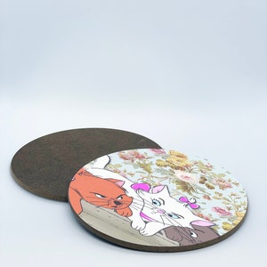May include: Two cartoon cats, one white and one orange, are lying on a wooden surface with a floral background. The white cat has a pink bow on its ear. A brown mouse is peeking out from behind the cats.