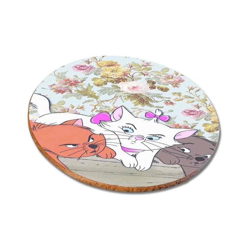 May include: A round coaster with a floral pattern featuring three cartoon cats. The white cat is in the center with a pink bow and the orange and gray cats are on either side.