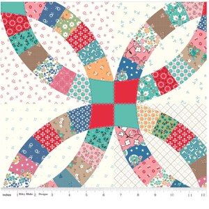 May include: A colorful patchwork fabric square featuring a double wedding ring design. The quilt block showcases a variety of floral and geometric patterns in shades of red, blue, pink, and teal, with a cream background. The fabric is marked with inches.
