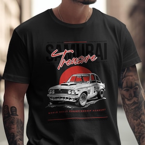 May include: Black t-shirt featuring a white vintage race car design with the text "SAMURAI Treasure" in red and white. The design includes a red sun and text that reads "WORLD RALLY CHAMPIONSHIP ACADEMY".