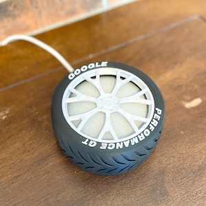 May include: A black tire-shaped Google Home smart speaker with the text "GOOGLE PERFORMANCE GT" printed on the side.