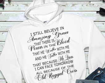 Puede incluir: Sudadera con capucha blanca con texto negro que dice "I still believe in Amazing Grace that there is Power in the Blood that He Walks with me and He Talks with me that because He Lives I can face tomorrow all because of the Old Rugged Cross"