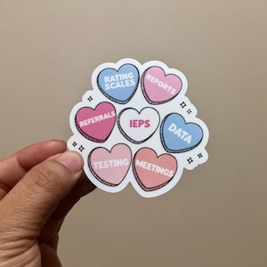 May include: A set of seven heart-shaped stickers with different colors and text. The text on the stickers includes "Rating Scales", "Reports", "Referrals", "IEPs", "Data", "Testing", and "Meetings".