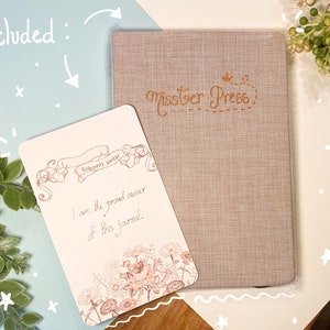 May include: A beige journal with the text "misster Press" in brown cursive lettering. The journal is accompanied by a card with a floral design and the text "Solemnly swear I am the proud owner of this journal."