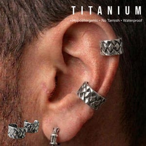 May include: Silver-colored titanium ear cuffs with a woven design are displayed on an ear. The word "TITANIUM" is at the top, with the words "Hypoallergenic, No Tarnish, Waterproof" below.