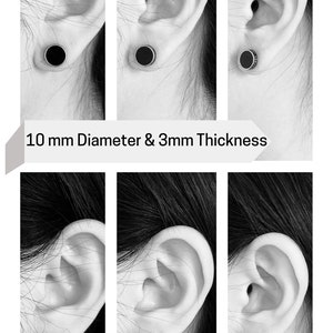 K&ouml;nnte beinhalten: Schwarze und silberne Ohr-Dehnungs-Schmuck, in mehreren Ansichten gezeigt, in ein Ohr eingesetzt. Die Dehnungs-Schmuck sind in zwei Gr&ouml;&szlig;en erh&auml;ltlich: 10 mm Durchmesser und 3 mm Dicke, und 8 mm Durchmesser und 3 mm Dicke. Der Text lautet "10 mm Diameter & 3mm Thickness" und "8 mm Diameter & 3mm Thickness".
