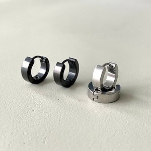 Pu&ograve; includere: Tre paia di orecchini a cerchio. Due paia sono grigio scuro e un paio &egrave; argentato. Gli orecchini hanno un design semplice e moderno, con un profilo piatto e rettangolare. Gli orecchini sono in metallo.