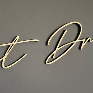 May include: A wooden sign with the words "Just Dream" written in cursive script.