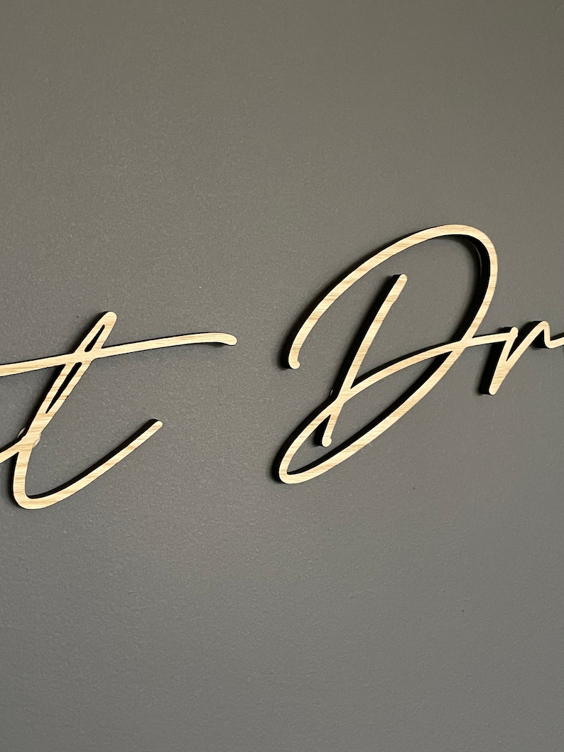 May include: A wooden sign with the words "Just Dream" written in cursive script.