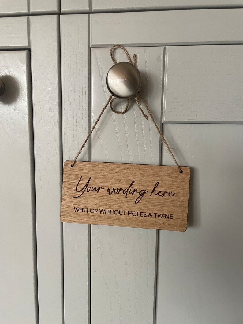 May include: A wooden sign with the text "Your wording here." and the words "with or without holes & twine" below. The sign is hanging from a string.