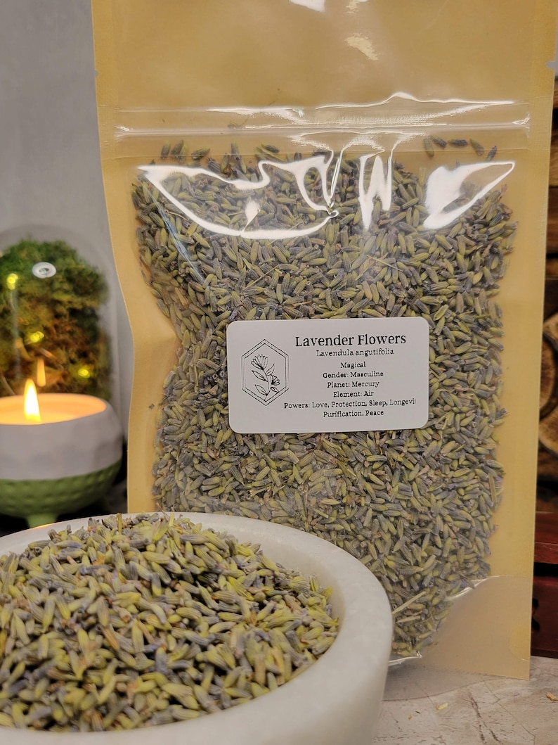 May include: A clear plastic bag filled with dried lavender flowers. The bag has a label that reads "Lavender Flowers, Lavendula angutifolia, Magical, Gender: Masculine, Planet: Mercury, Element: Air, Powers: Love, Protection, Sleep, Longevity, Purification, Peace."