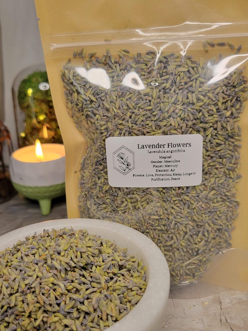 May include: A clear plastic bag filled with dried lavender flowers. The bag has a white label with the text "Lavender Flowers, Lavendula angutifolia, Magical, Gender: Masculine, Planet: Mercury, Element: Air, Powers: Love, Protection, Sleep, Longevity, Purification, Peace."