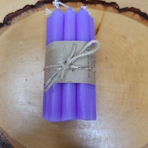 May include: A bundle of six slender purple taper candles held together by a brown paper band and tied with a piece of natural twine. The paper band features the printed text My Magic Place Shop and the candles have white cotton wicks at the top.