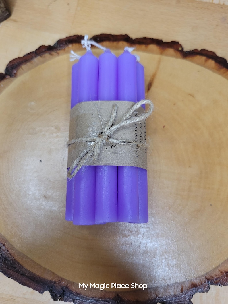 May include: A bundle of six slender purple taper candles held together by a brown paper band and tied with a piece of natural twine. The paper band features the printed text My Magic Place Shop and the candles have white cotton wicks at the top.