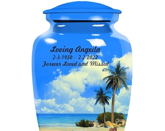 May include: Blue cremation urn with a beach scene and the text "Loving Angeila 2-3-1950 - 2-2-2022 Forever Loved and Missed".