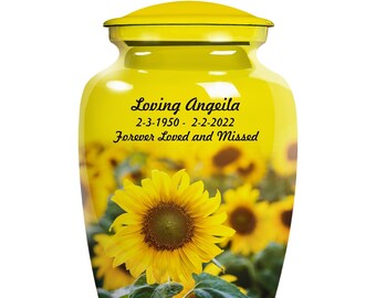 May include: Yellow ceramic urn with a sunflower design and the text "Loving Angeila 2-3-1950 - 2-2-2022 Forever Loved and Missed".
