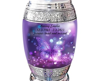 May include: A silver and purple cremation urn with a butterfly design. The urn has a personalized inscription that reads "Loving Emelia 12-3-1945 - 2-3-2023 Forever loved and missed".