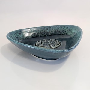 May include: A set of three ceramic mugs with a speckled, matte finish. The mugs are in shades of cream, light gray, and dark gray. Each mug has a simple, minimalist design, perfect for coffee or tea.