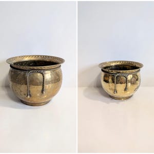 Puede incluir: Una maceta redonda de latón con textura martillada y acabado pulido. El borde presenta un patrón decorativo de muescas, y un acento de latón estilo cuerda trenzada rodea la parte superior del cuenco, cayendo en tres bucles distintos.