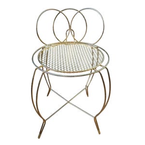 May include: A gold-toned metal chair featuring a circular seat with a diamond-patterned mesh surface. The backrest is composed of three interconnected circular wire frames. The chair stands on four curved legs connected by a cross-brace support.