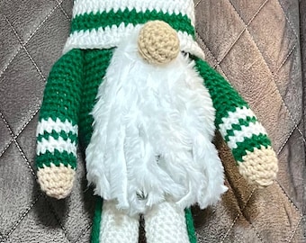 May include: A handcrafted crochet gnome doll featuring a tall green and white striped pointed hat with the Jets logo patch, a long white faux fur beard, a round beige nose, green and white striped arms, and long white legs with green accents.